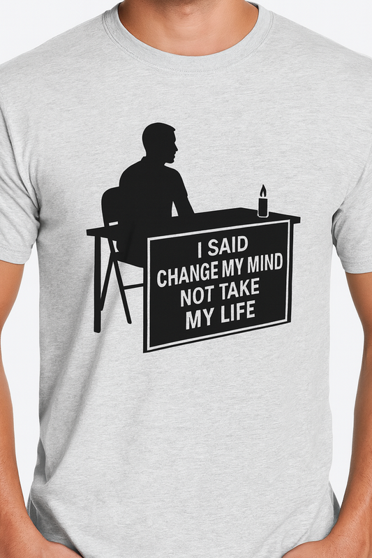 Man wearing a t-shirt with bold black silhouette artwork of a seated figure at a table with a lit candle. The sign on the table reads: 'I SAID CHANGE MY MIND NOT TAKE MY LIFE' — a tribute design honoring free speech and the legacy of Charlie Kirk.