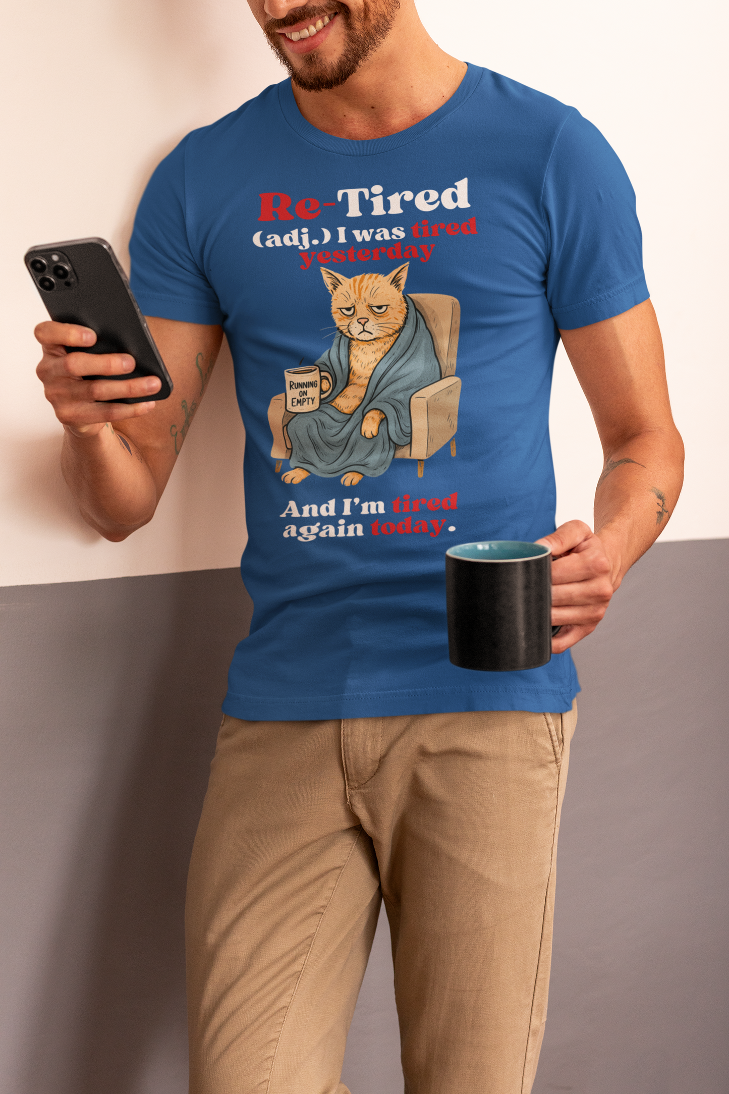 Man wearing a blue “Re-Tired” t-shirt featuring a grumpy orange cartoon cat wrapped in a robe and holding a “Running on Empty” coffee mug. Humorous Father’s Day shirt for tired dads, cat lovers, or sarcastic pet dads.
