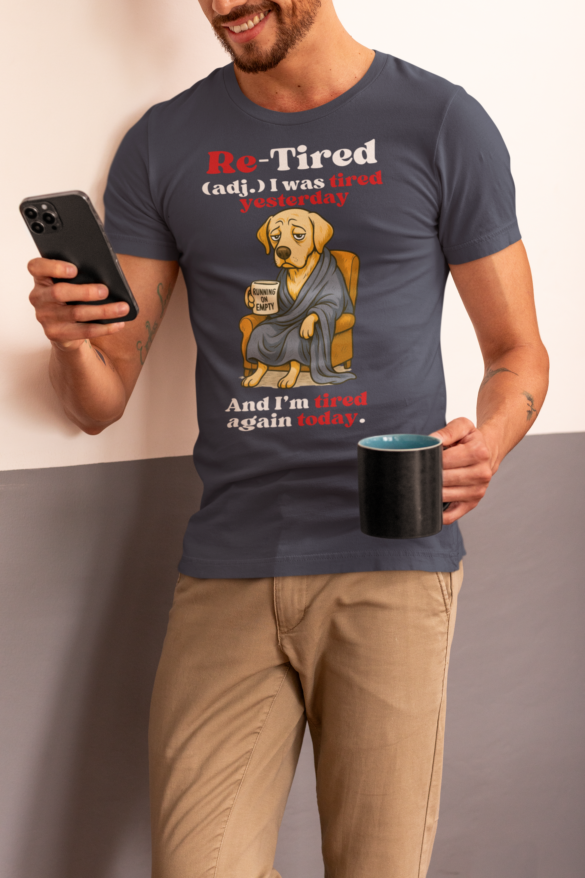 Smiling man wearing a navy “Re-Tired” t-shirt featuring a tired cartoon dog holding a coffee mug that says “Running on Empty,” with the caption “I was tired yesterday and I’m tired again today.” Perfect Father’s Day gift for dog dads, tired dads, or retired men.